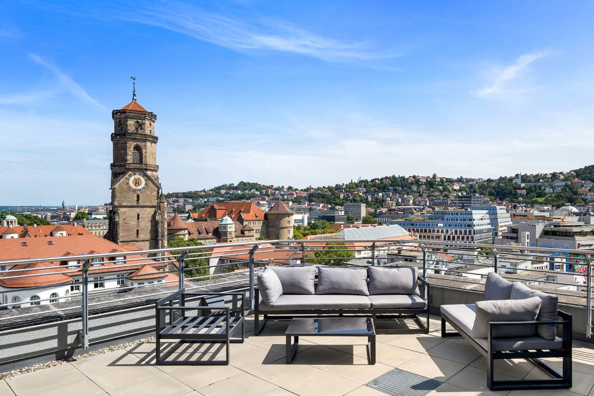 Dachterrasse unseres Stuttgarter Standorts mit Sitzgruppe und Blick auf die Stiftskirche und die Innenstadt